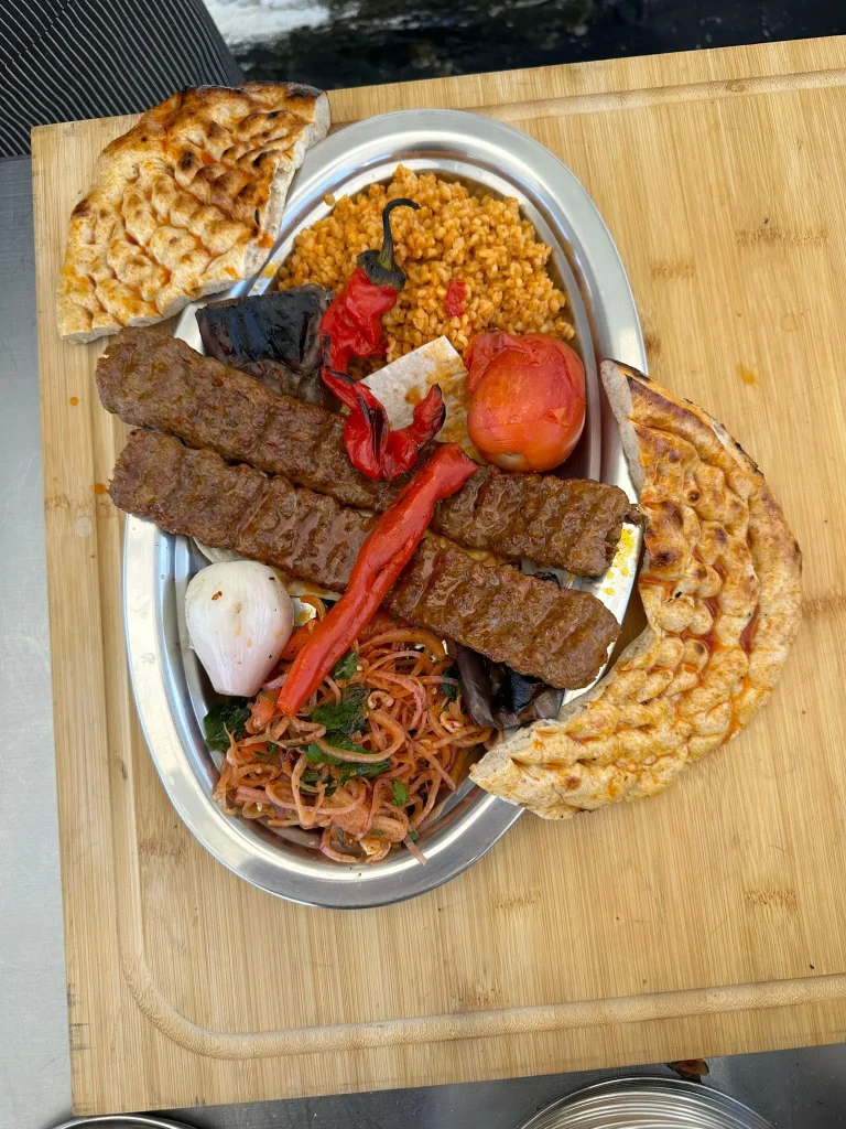 Adana kebab plate with bulgur and mixed salad